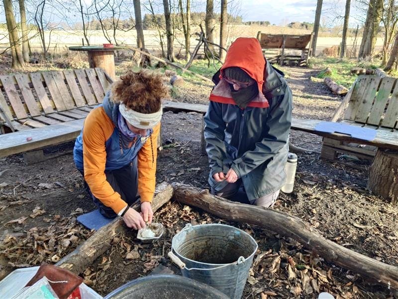 2 adults learning to light a fire